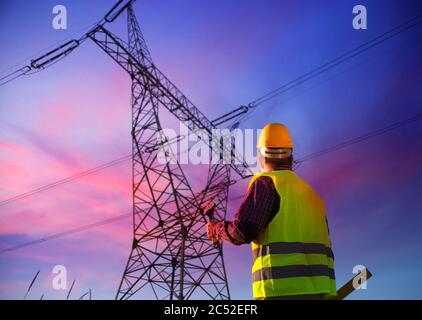 Engineer during power line inspection. Electrician at work. Production and supply of energy from power plants. Stock Photo