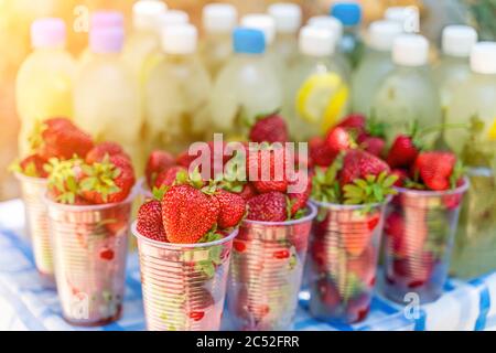 Abstract bokeh with fresh strawberry and background from mojito or lemonade with mint. Summer time beach food and drink poster concept Stock Photo