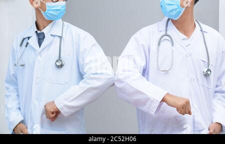 Two doctors bumping elbows instead of shaking hands