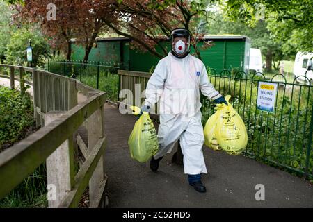 A city council worker carries rubbish from a coronavirus testing centre at Spinney Hill Park in Leicester, after the Health Secretary Matt Hancock imposed a local lockdown following a spike in coronavirus cases in the city. Stock Photo