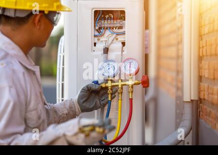 Technician checking an Air conditioning liquid gauge, Thailand Stock Photo