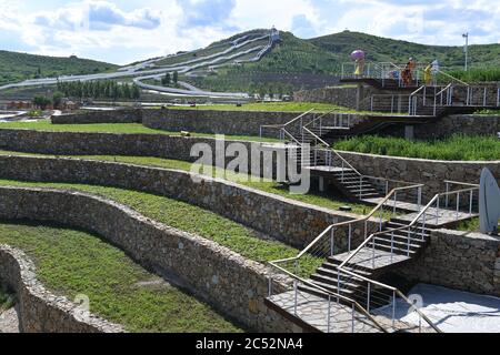 Ulanhot, China's Inner Mongolia Autonomous Region. 30th June, 2020. Tourists visit Tianjun Mountain scenic spot in Ulanhot City, north China's Inner Mongolia Autonomous Region, June 30, 2020. Tianjun Mountain, located in the suburb of Ulanhot, was once cratered and lack of vegetation due to the extraction of stones in the past time. In recent years, the local government is committed to ecological restoration and has transformed the barren mountain into a scenic spot to boost local tourism. Credit: Bei He/Xinhua/Alamy Live News Stock Photo