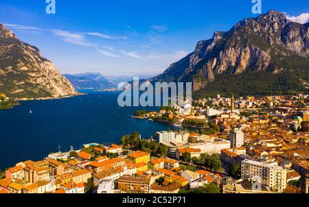 Colorful mountain scenery with Italian city of Lecco on shore of picturesque Lake Como on sunny day, Italy Stock Photo