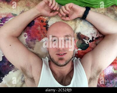 Overhead view of a bald man lying on a rug Stock Photo
