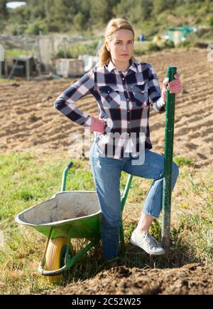 Woman farmer loading garden wheelbarrow with manure Stock Photo - Alamy