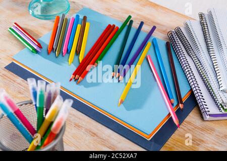 Picture of multicolored pencils on table with papers and notebooks Stock Photo