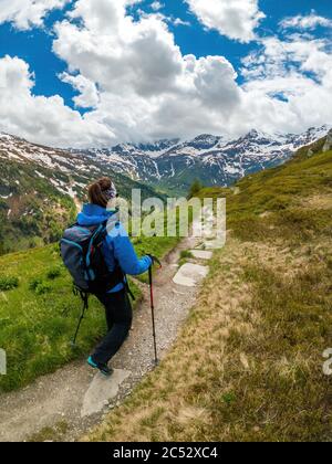 Young woman hiking on footpath in the Austrian Alps near Gastein, Salzburg, Austria Stock Photo