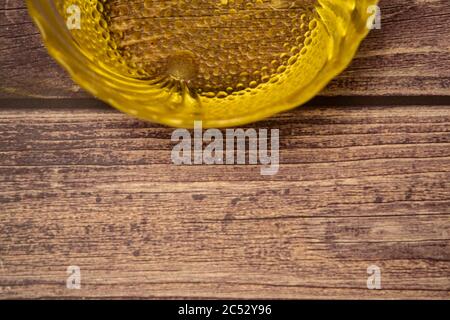 Olive oil in a glass bowl on a wooden background. Close up Stock Photo