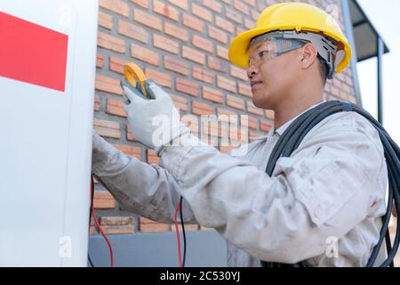 Engineer installing an air conditioning unit Stock Photo