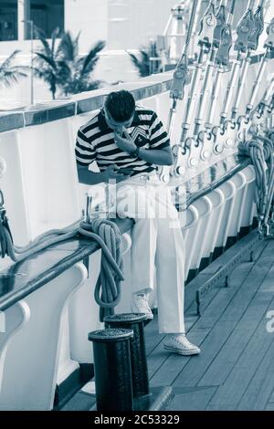 Sailor looking at mobile phone on Mexican navy ship Stock Photo