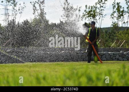 Ulanhot, China's Inner Mongolia Autonomous Region. 30th June, 2020. A worker waters the lawn at Tianjun Mountain scenic spot in Ulanhot City, north China's Inner Mongolia Autonomous Region, June 30, 2020. Tianjun Mountain, located in the suburb of Ulanhot, was once cratered and lack of vegetation due to the extraction of stones in the past time. In recent years, the local government is committed to ecological restoration and has transformed the barren mountain into a scenic spot to boost local tourism. Credit: Liu Lei/Xinhua/Alamy Live News Stock Photo