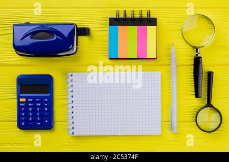 Blank notepad for copy space and retro stationery office accessories on yellow wooden table. Stock Photo