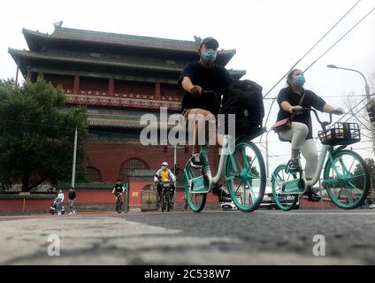 Beijing, China. 30th June, 2020. Chinese wear protective face masks as they bicycle through a historic area normally bustling with tourists in Beijing on Tuesday, June 30, 2020. China's capital remains under a soft lockdown due to new infections detected at a public market. Photo by Stephen Shaver/UPI Credit: UPI/Alamy Live News Stock Photo