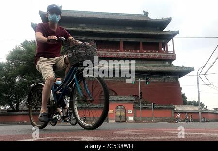 Beijing, China. 30th June, 2020. Chinese wear protective face masks as they bicycle through a historic area normally bustling with tourists in Beijing on Tuesday, June 30, 2020. China's capital remains under a soft lockdown due to new infections detected at a public market. Photo by Stephen Shaver/UPI Credit: UPI/Alamy Live News Stock Photo