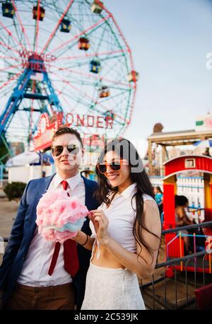 Young couple eating cotton candy at Coney Island, Brooklyn, New York City Stock Photo
