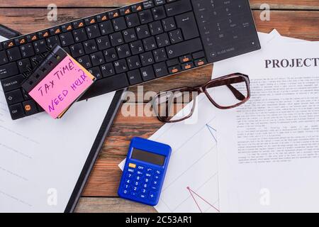 Flat lay black keyboard, glasses blue calculator and documents on the wooden table. Stock Photo