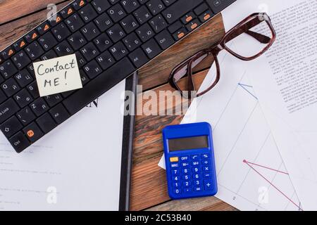 Working place with keyboard glasses document and blue calculator. Stock Photo