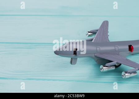 Close-up small grey toy airplane on turquoise background. Stock Photo