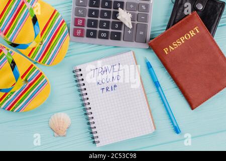Travel concept with sandals, passport and calculator on blue background. Stock Photo