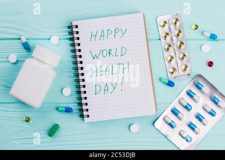 Different pills with notebook and blister packs on blue background. Stock Photo