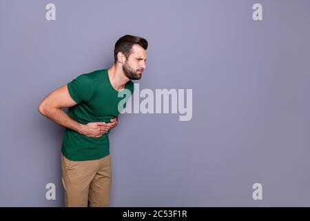 Profile side photo of frustrated man touch hands stomach suffer pain vomit copyspace wear pants trousers isolated over gray color background Stock Photo