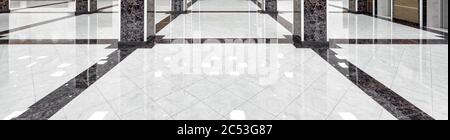 Marble floor of a luxury lobby of company or hotel. Panorama of a cleaned washed floor in corporate hallway. Shiny floor with reflections after profes Stock Photo