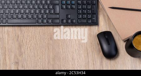office table with notebook, computer keyboard, mouse, cup of coffee,  copy space Stock Photo