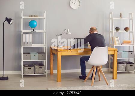 Back view. Senior man working online business meeting or webinar Stock Photo