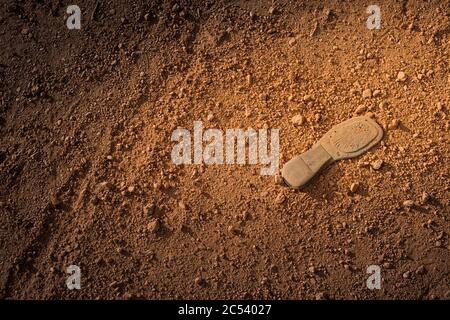 old shoe sole lies on red sandy bottom Stock Photo
