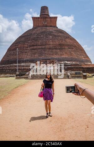 young tourist is photographed in front of a dome of the former capital of Sri Lanka Stock Photo