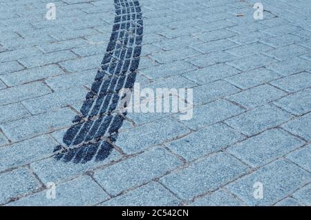 Black wheel trace on the cobblestone ground Stock Photo