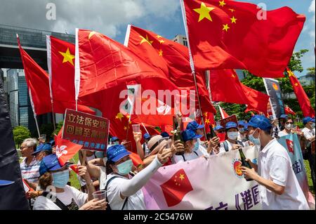 Pro-China supporters rally and celebrate with flags at Tamar Park hours after Chinese government and Hong Kong Chief Executive Carrie Lam passed the National Security Law in Hong Kong. Stock Photo