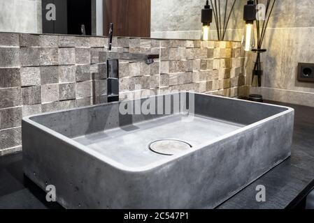 Moscow - March 25, 2018: Modern stylish restroom in a hotel or residential house. Interior design with concrete sink in the bathroom. Contemporary min Stock Photo