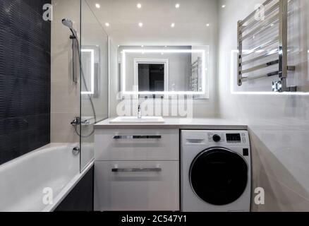 Moscow - June 5, 2018: Interior of bathroom in hotel or residential house. Interior design with light and dark tiles. Modern bathroom with shower, was