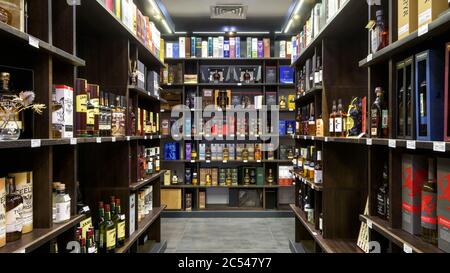 Moscow – Oct 6, 2019: Panoramic view of wine shop interior. Various wine bottles sale on wooden shelves in supermarket. Inside the luxury liquor store Stock Photo