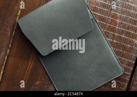 black leather case for tablet. eco leather case on a wooden background. Stock Photo