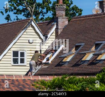 Builders repairing skylight window. Stock Photo