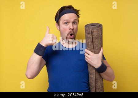 Handsome athletic man at the gym with a mat showing approving gesture. Stock Photo