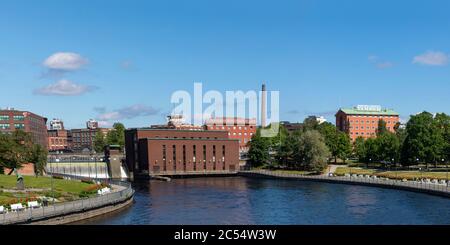 Tammerkoski -channel is most iconic landmark in City of Tampere. Old power station and factory buildings dominate the view on warm summer day. Stock Photo