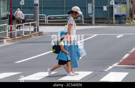 Japanese mother sending child to school in Shinagawa train stration, Tokyo, Japan Stock Photo