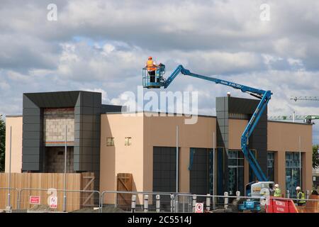 Construction Workers on a Retail Unit Building Site Nearing Completion Stock Photo