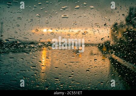 Raindrops on the window with street bokeh lights Stock Photo