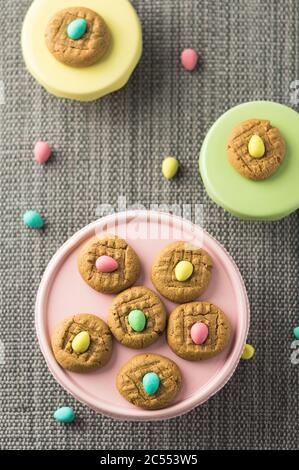Easter cookies above flat top view. Homemade peanut butter cookies desserts with a Easter holiday twist! Chocolate easter eggs are added on top of eac Stock Photo