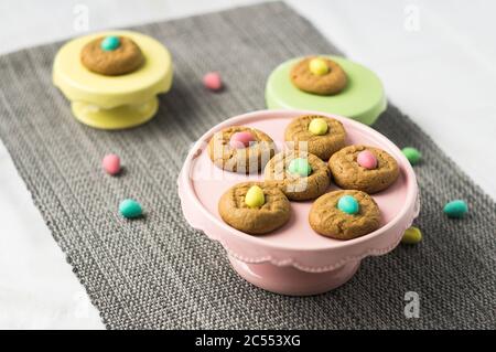 Easter cute mini eggs cookies. Homemade peanut butter cookies desserts with a Easter holiday twist! Chocolate mini easter eggs are added on top of eac Stock Photo