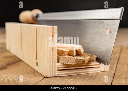 Cutting wooden slats at an angle. Small works in the carpentry shop. Workplace home workshop. Stock Photo