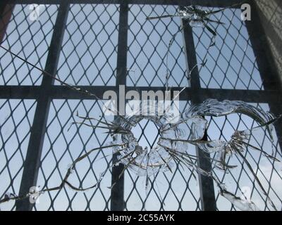 Closeup shot of broken window glass with bullet holes Stock Photo