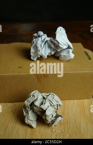 Vertical high angle shot of two crumpled pieces of paper on a wooden surface Stock Photo