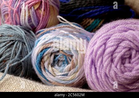 Close view of cozy colorful yarn skeins for knitting or crochet with a white blanket Stock Photo