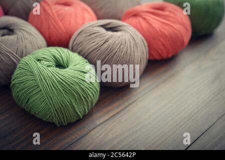 Colored yarn balls on wooden background closeup Stock Photo