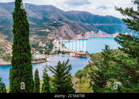 Frourio peninsula and Assos village with beautiful sea bay and cypress trees in foreground. Kefalonia island, Greece. Stock Photo